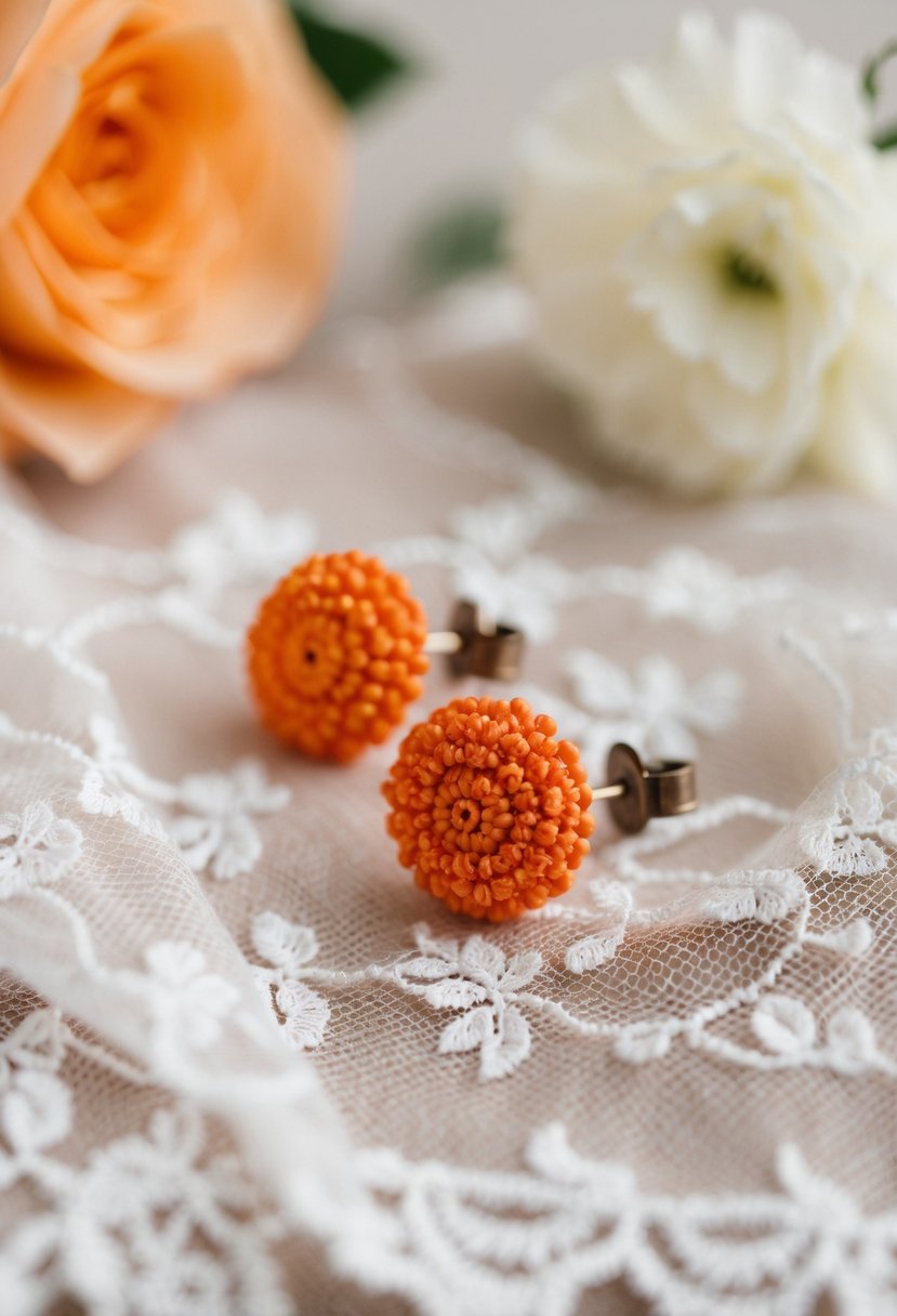 A pair of orange wedding earrings resting on a delicate lace fabric with a soft, romantic background