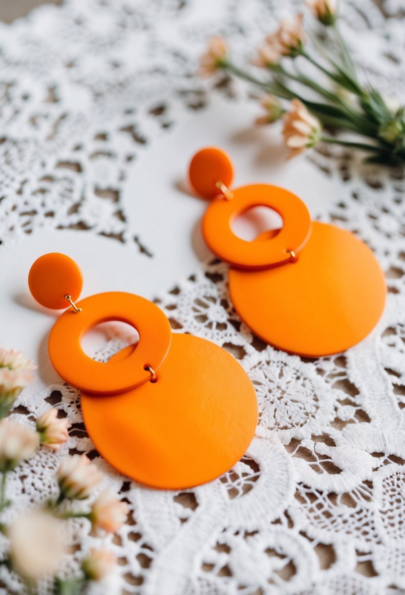 Vibrant tangerine statement earrings displayed on a white lace background with delicate floral accents