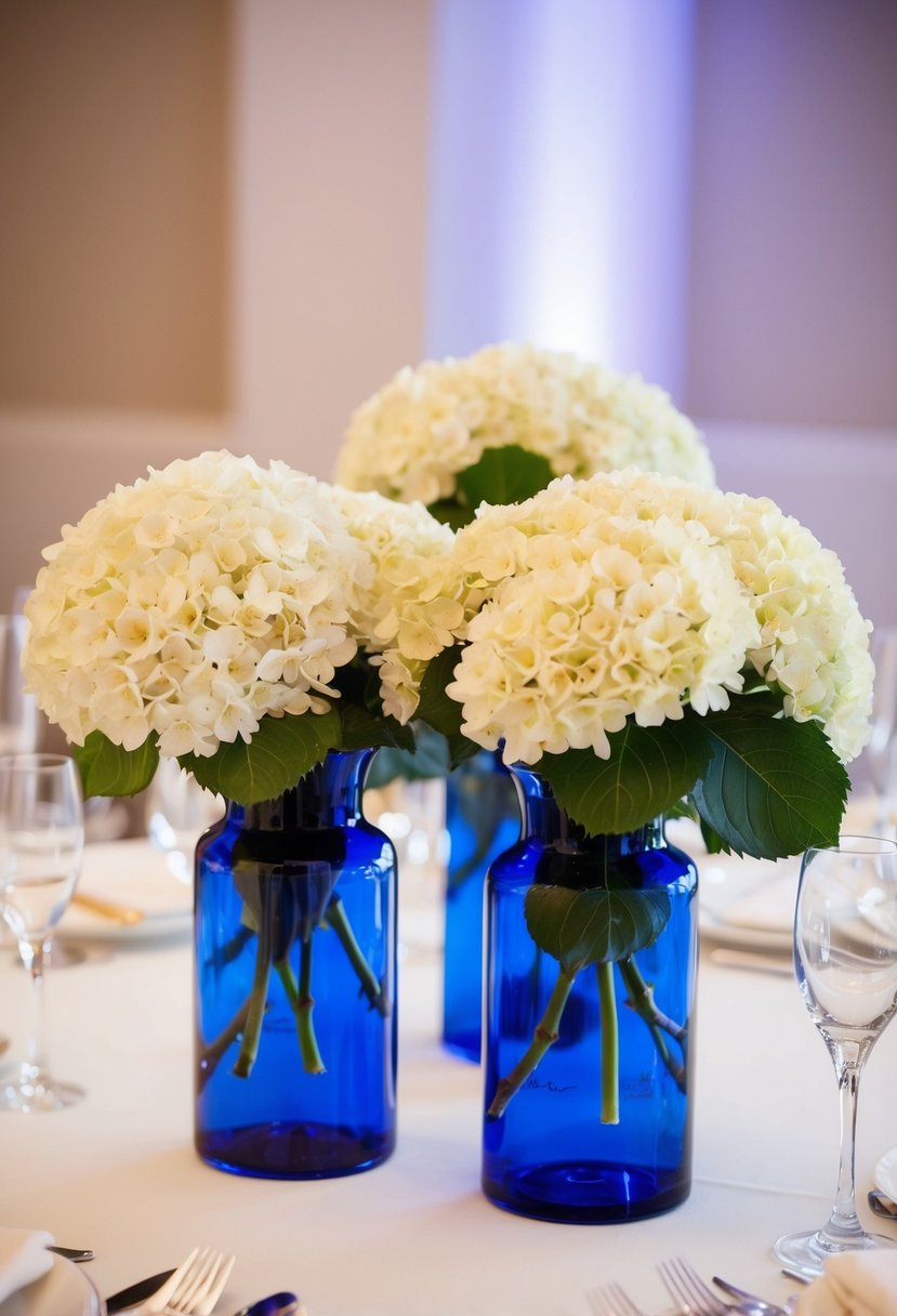 Blue glass vases hold hydrangea centerpieces on a wedding table