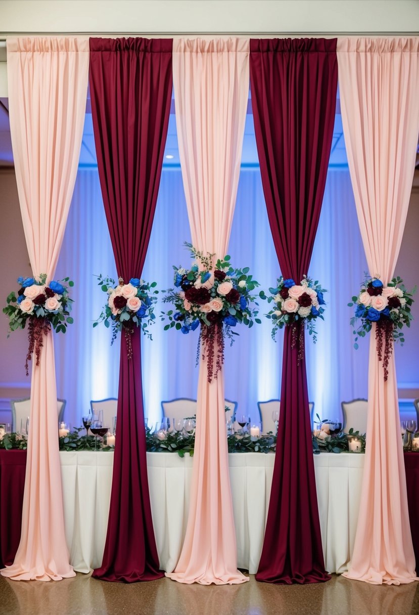 Blush pink and burgundy drapes flowing in a wedding reception hall, accented with blue and burgundy floral arrangements