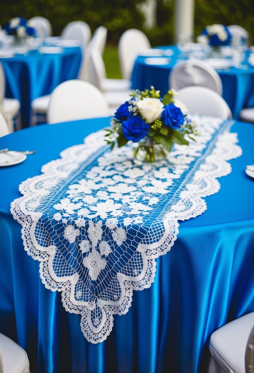 A blue satin tablecloth with a white lace overlay, adorned with blue and white wedding table decorations