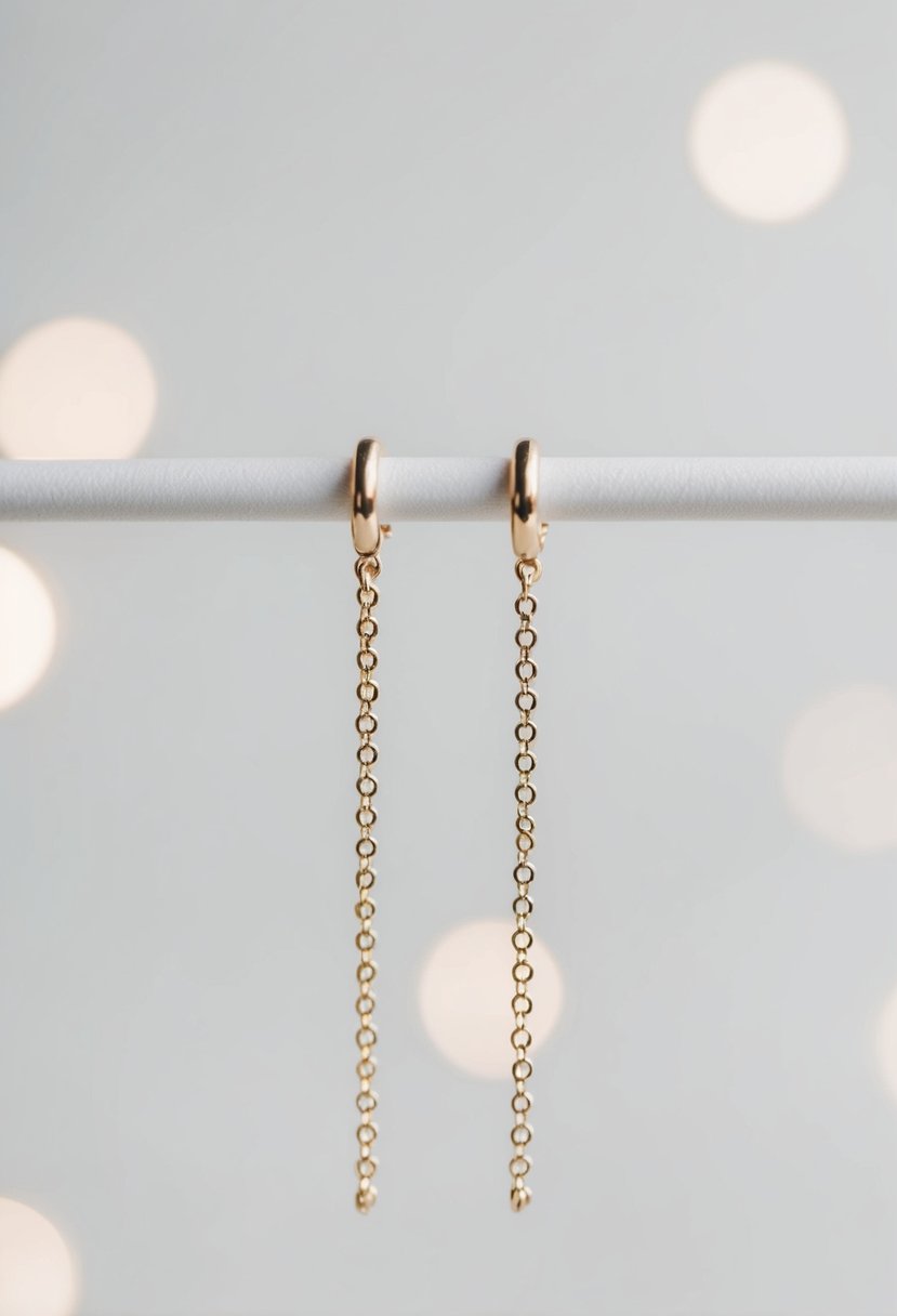 A close-up of minimalist chain earrings against a plain background