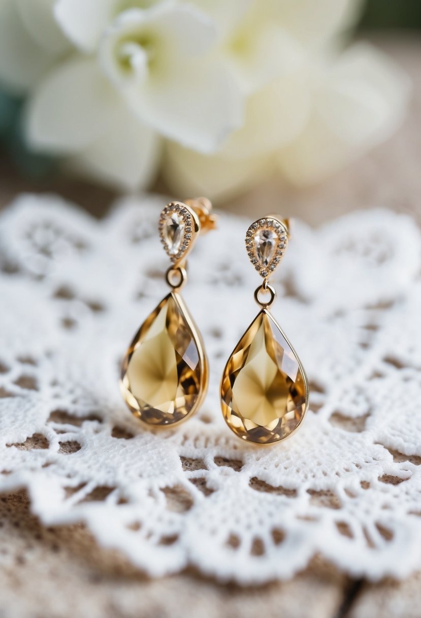 Two delicate teardrop champagne earrings on a white lace background