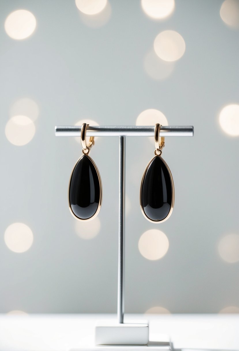 Two sleek oval drop earrings displayed on a white minimalist background