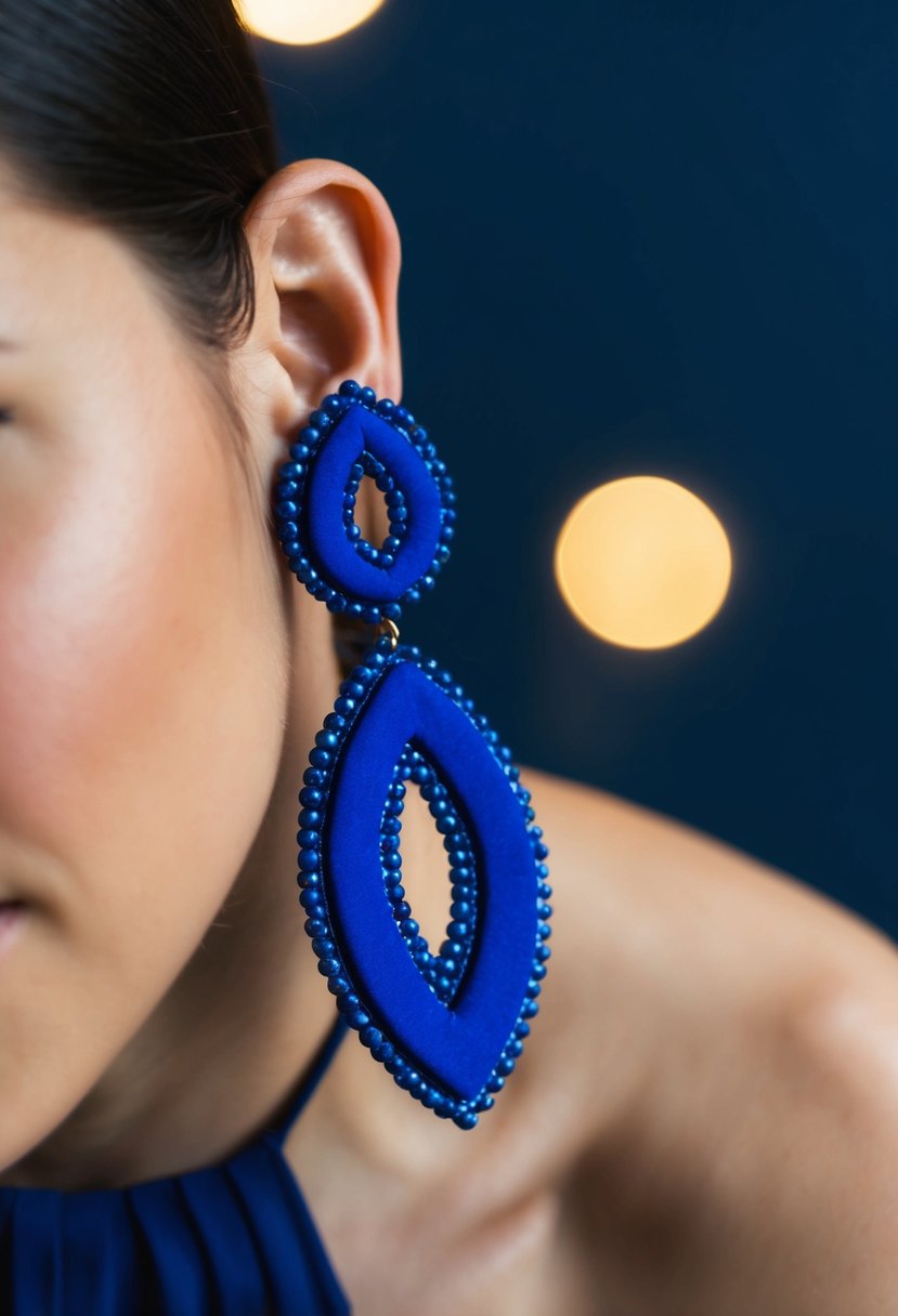 A close-up of cobalt blue statement earrings against a navy background, with soft lighting to highlight their intricate design